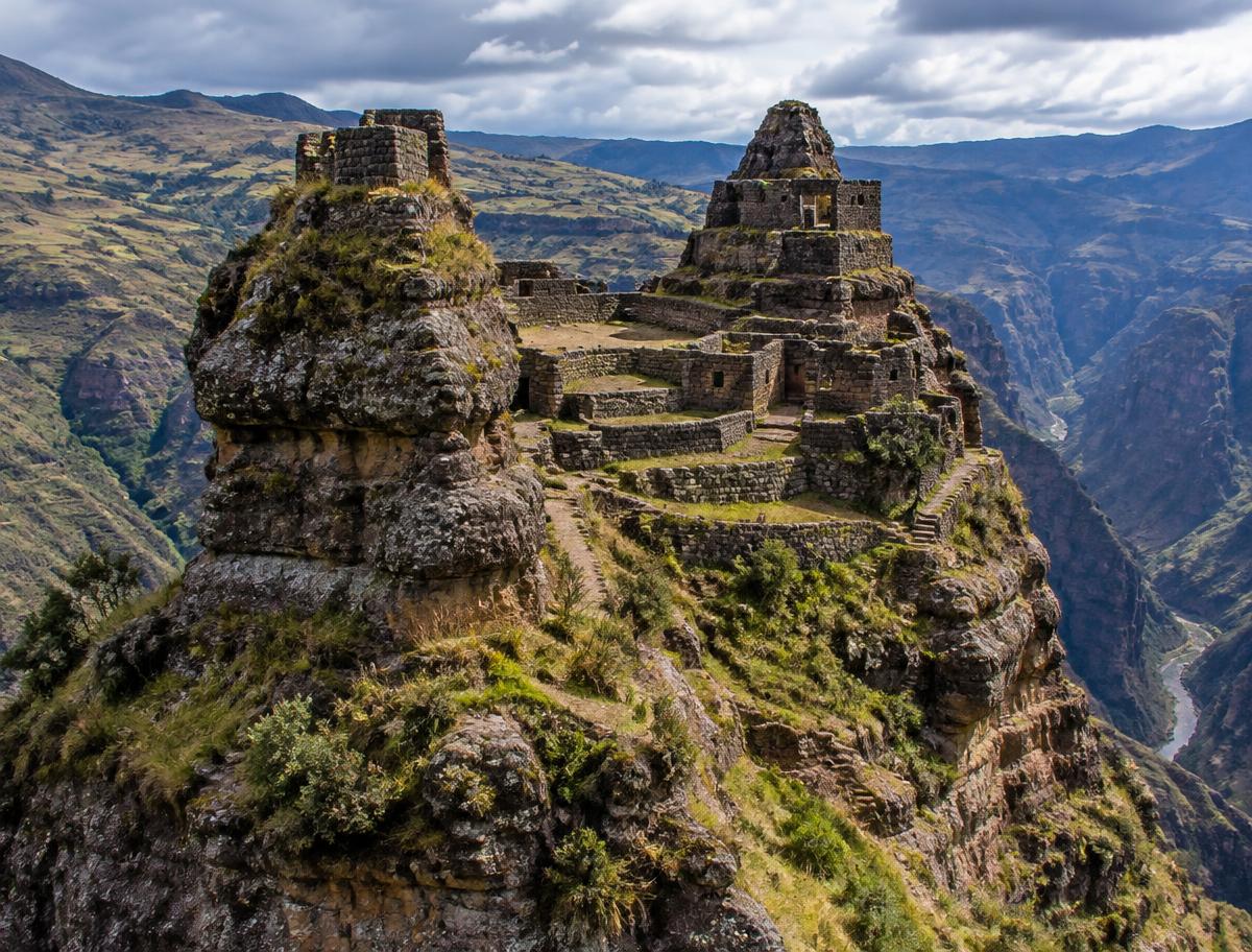 Waqrapukara's walls on horn-shaped rocks above a deep canyon